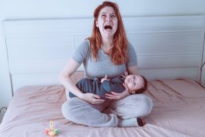 A woman holds a child in her arms and cries. Postpartum depression.